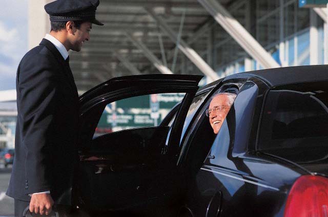 Chauffeur Holding a Suitcase and Opening a Door For a Mature Businessman